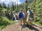 3 people standing above a waterfall