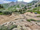 Looking down a rocky climb with people and 4-wheel vehicles below