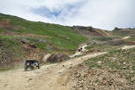 A group of 4-wheel vehicles climbing a mountain road