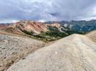 From the edge of a dirt road, red peaks on the left and granite peaks ahead