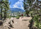 Person standing looking down at the town below in the mountains