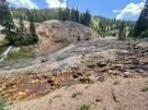 Copper mine tailings beside a copper colored stream