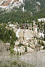 Remains of a mine building surrounded by mine tailing piles and forest