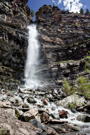Wide view of a water fall with the stream running over the rocks below