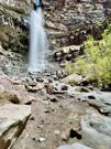 A low view of a waterfall from the ground and stream