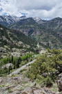 A view of a road below adn snow covered peaks in the distance