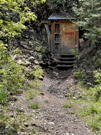 A closed up mine shaft with a locked door with painted in red Danger