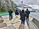 Fellow adventurers on the front of our ship enjoying the clouds draped along the cliff sides