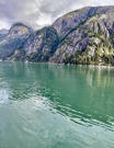 A few small icebergs in the waters below the granite mountains