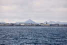 Harbor side buildings near Reykjavik with volcanic peaks in the background