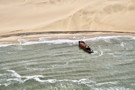 Shipwreck that is still in the ocean but will one day also be reclaimed by the advancing dunes