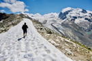 Trail continues with a snow bank along the ridge, glacier in the background