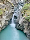Waterfall from a pool plunges into another glacial pool of water