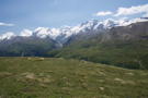 Looking across the valley at snow covered mountains with roads and trails crossing the slopes below